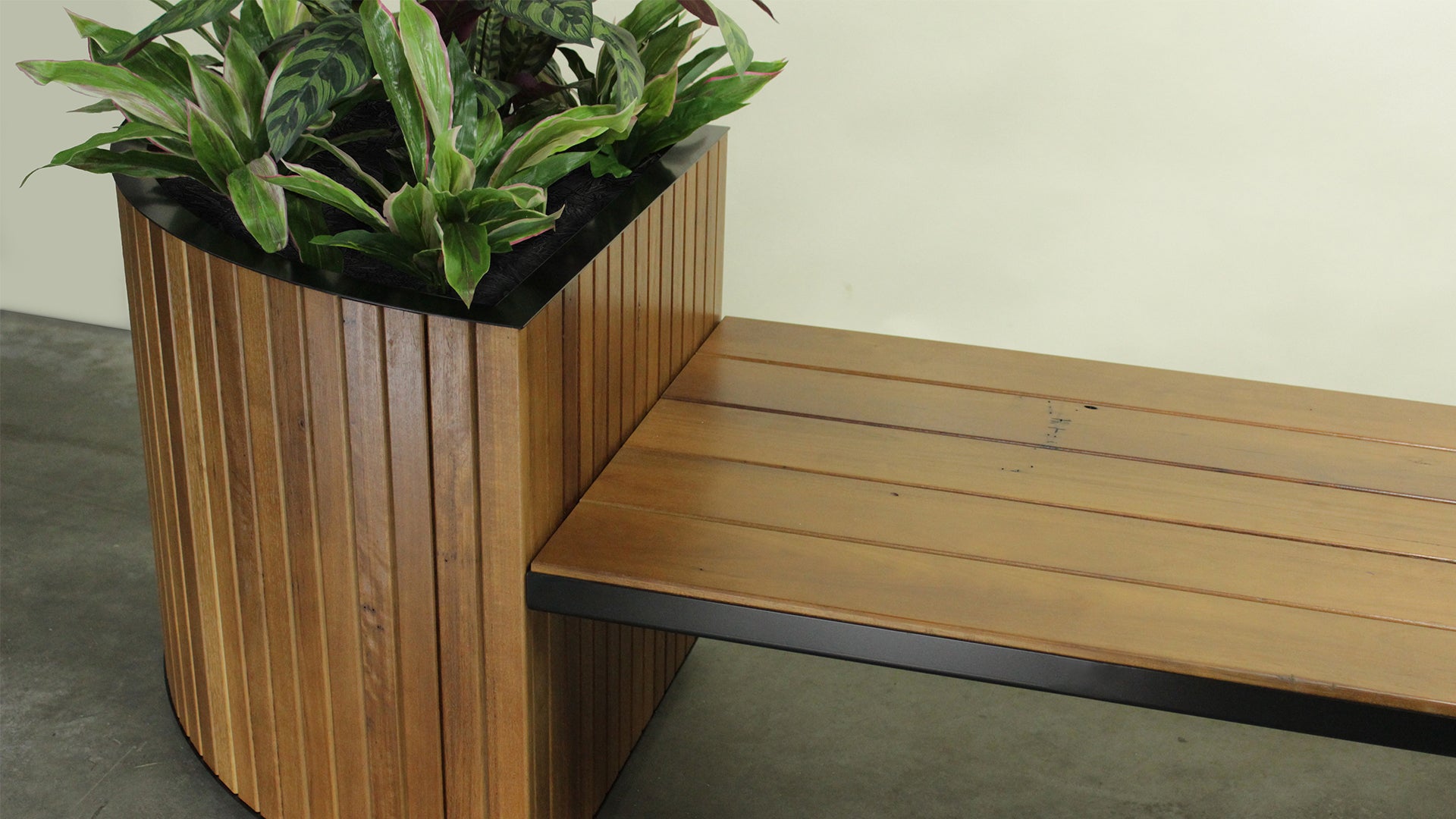 Looking for a custom planting solution? Image of walnut stained Australian hardwood timber planter box with bench seat and metal details. Custom designed to suit clients space made in our Melbourne workshop.